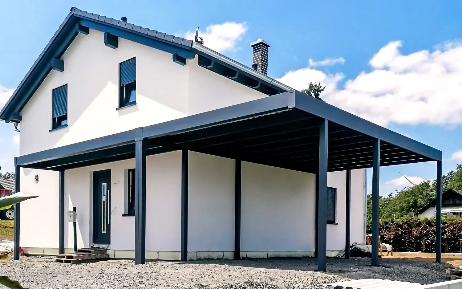 Flachdachcarport führt um die Ecke eines Einfamilienhauses